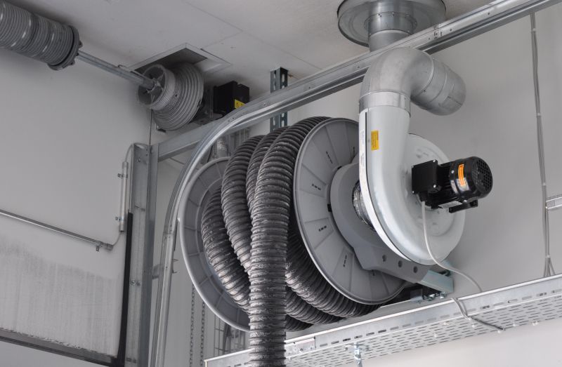 Système d'aspiration des gaz d'échappement monté au plafond de Nederman avec grand enrouleur de tuyau et ventilateur radial.