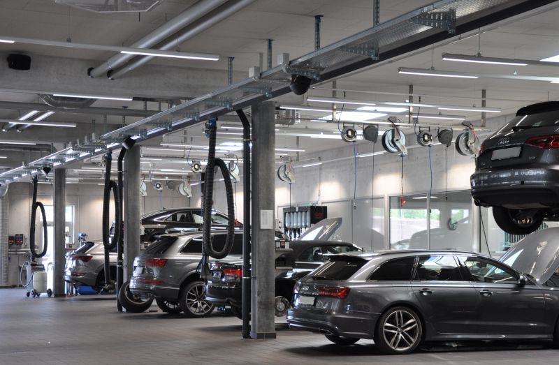 Garage automobile avec des Audi, certaines sur ponts élévateurs ; rouleaux Nederman et bras visibles.