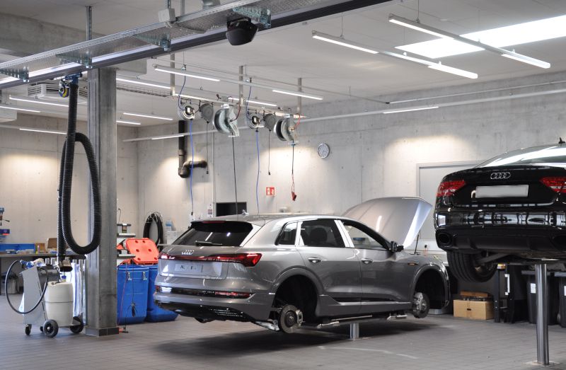 Garage automobile avec des Audi sur ponts élévateurs ; rouleaux Nederman et bras visibles.